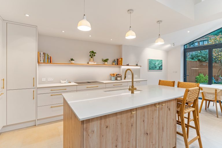 Contemporary kitchen design in Putney with white cabinetry and oak island